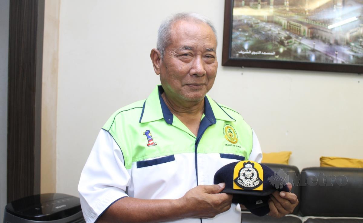 Mohd Dairubi Mustakim menunjukkan beret yang menjadi kenangannya ketika berkhidmat dengan Pasukan Polis Hutan. FOTO MOHD AMIN JALIL