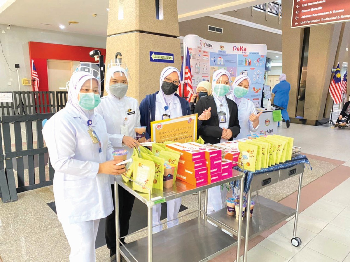 PETUGAS barisan hadapan Hospital Putrajaya ceria menerima sumbangan makanan.