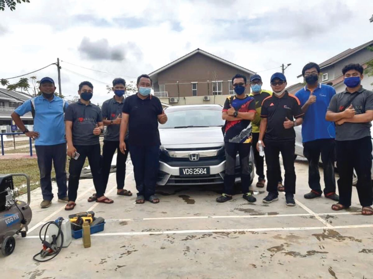 MUHAMMAD Irfan (tiga dari kiri) bersama rakan dan pensyarah selepas selesai membaiki kereta yang ditenggelami banjir.