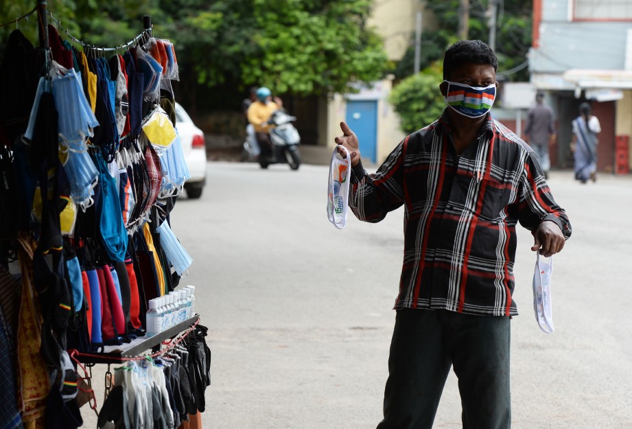 PENIAGA di Hyderabad memakai pelitup muka untuk menarik pengunjung. FOTO AFP 