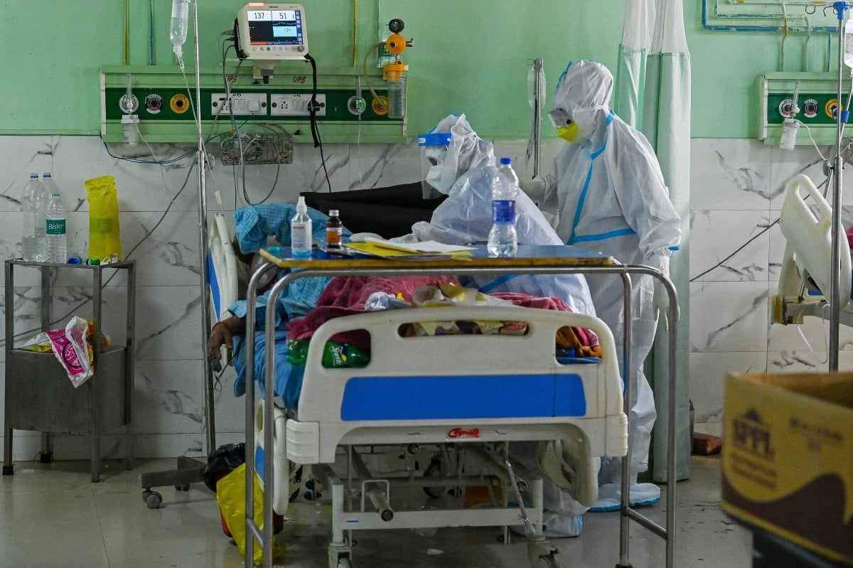 PETUGAS kesihatan memakai pakaian perlindungan diri (PPE) ketika merawat pesakit Covid-19 di sebuah hospital di India. FOTO AFP 