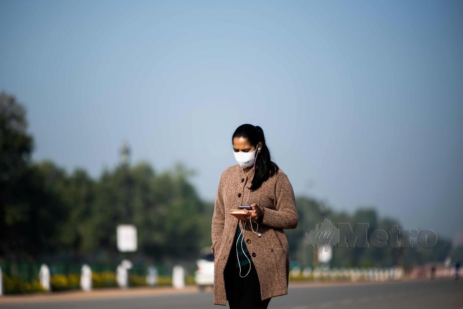 SEORANG wanita memakai penutup hidung dan mulut sebagai langkah berjaga-jaga dari wabak Covid-19. FOTO AFP