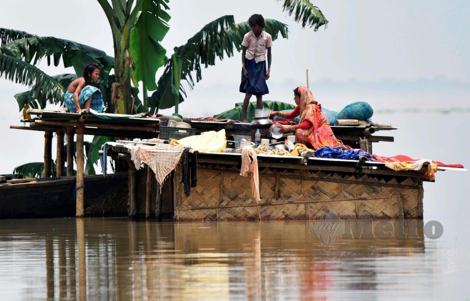  PENDUDUK terpaksa menyelamatkan diri dengan duduk di atap rumah akibat banjir besar.