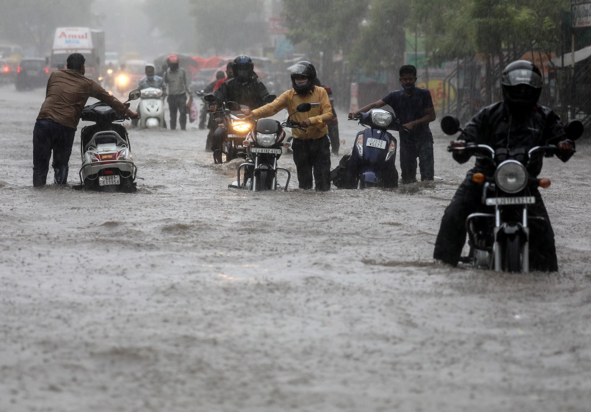 PENDUDUK di Ahmedabad, Gujarat, meredah jalan dinaiki air susulan hujan lebat akibat Taufan Tauktae. FOTO EPA 