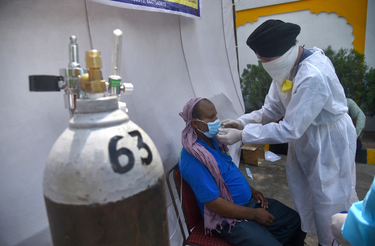 ANTARA individu di India yang disyaki menghidap Covid-19 menerima bantuan bekalan oksigen. FOTO EPA 