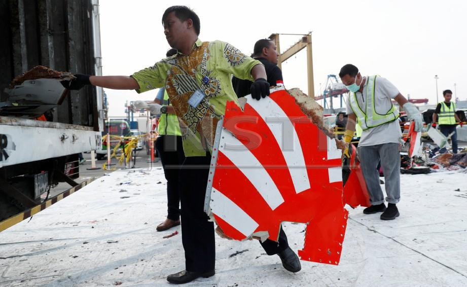 PEKERJA mengumpul serpihan pesawat Lion Air JT610 yang terhempas. FOTO Reuters