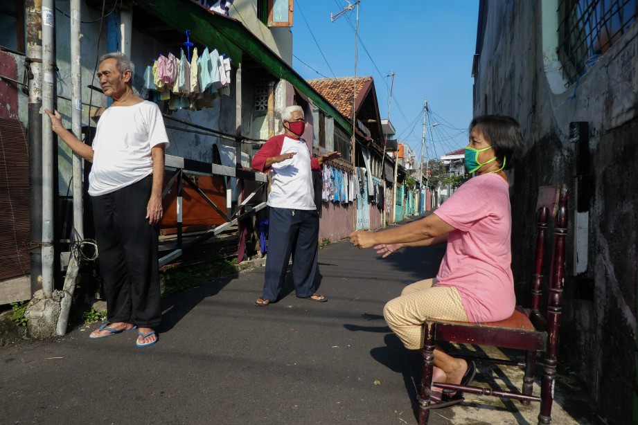 PENDUDUK Jakarta berada di luar rumah kerana percaya sinar matahari dapat meningkatkan imuniti badan. FOTO AFP