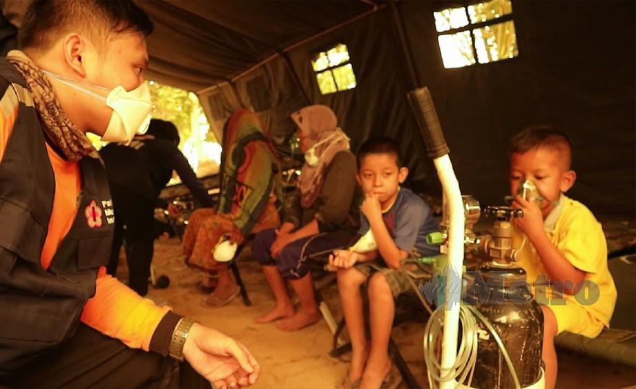 Sukarelawan Palang Merah memantau keadaan kanak-kanak yang mendapat bantuan oksigen di Jambi, Indonesia hari ini. Foto AFP
