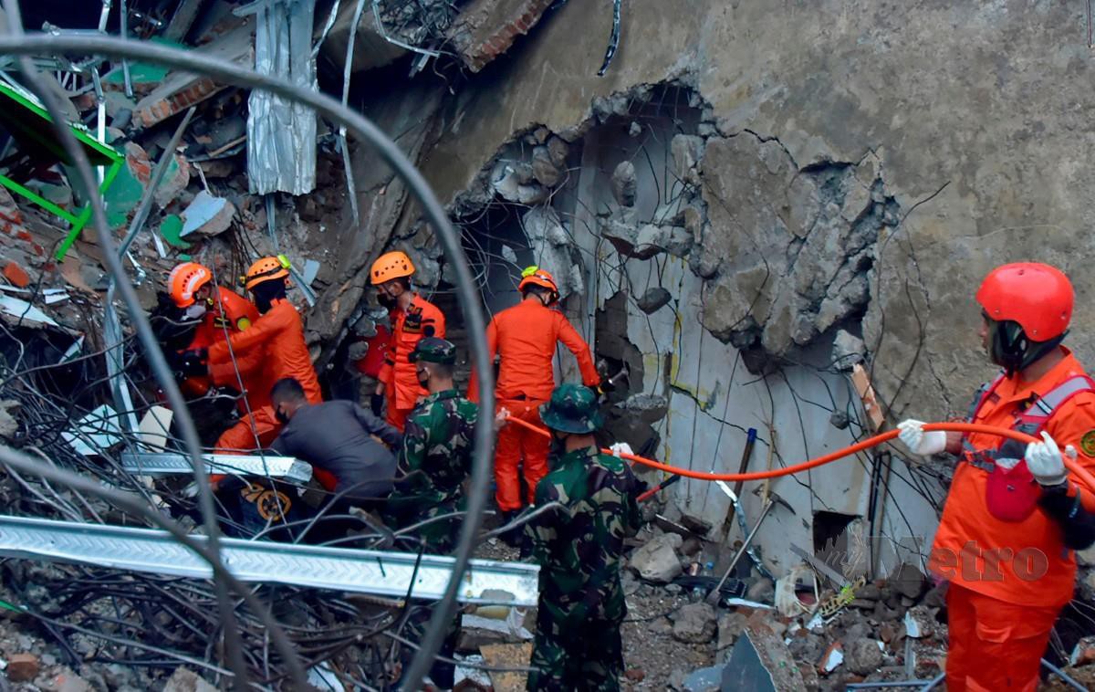 PASUKAN mencari dan menyelamat mengesan mangsa yang terperangkap bawah runtuhan akibat gempa bumi di Mamuju, Indonesia. FOTO AFP
