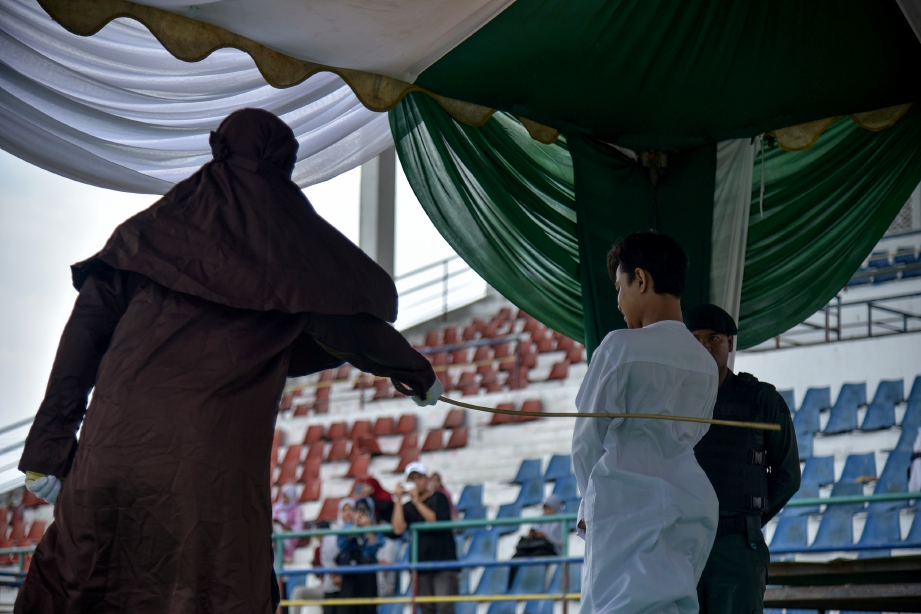 PESALAH dihukum sebat 100 kali di hadapan orang ramai di sebuah stadium Lhokseumawe, Aceh. FOTO: AFP