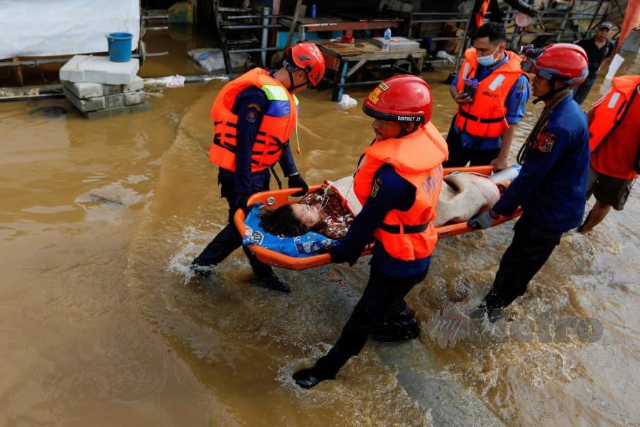 ANGGOTA penyelamat mengusung wanita di kawasan terjejas banjir di Jakarta. FOTO Reuters