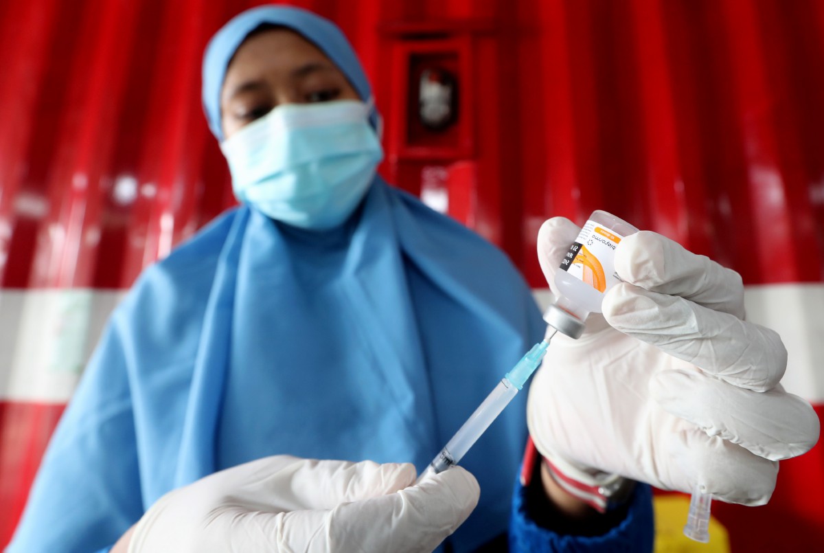 PETUGAS menyediakan dos vaksin untuk pemandu gojek (teksi motosikal) di sebuah pusat vaksinasi di Jakarta. FOTO EPA 