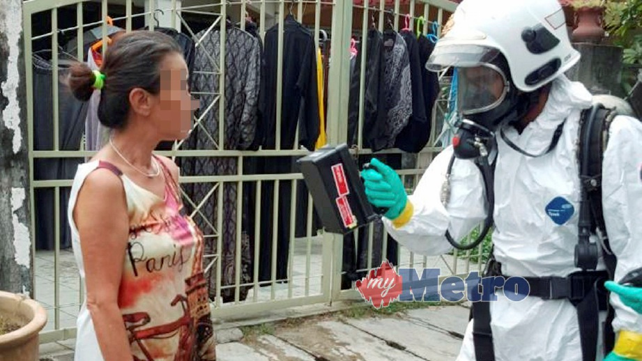 ANGGOTA bomba mengesan jika ada  pencemaran radioaktif pada wanita di Taman Indah Jaya. FOTO ihsan Bomba