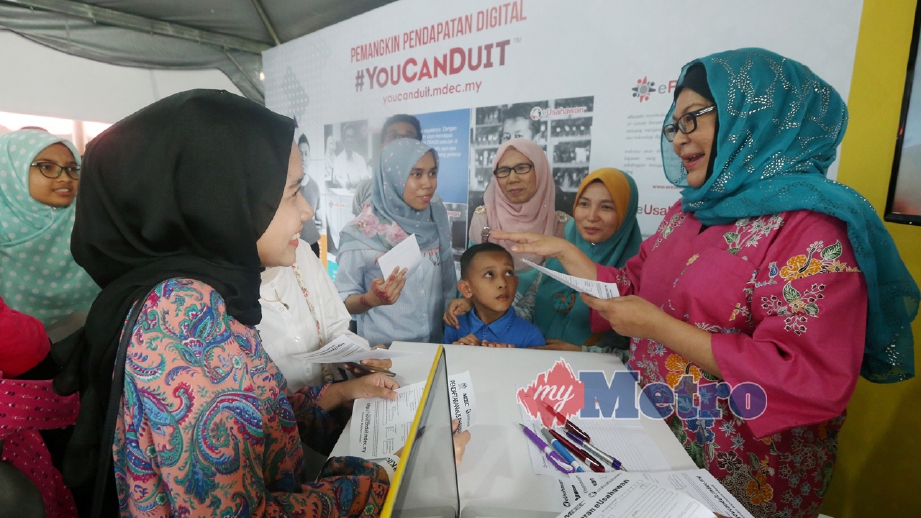 MENTOR selebriti YouCanduit, Erma Fatima (kanan) memberi penerangan kepada pengunjung berkaitan eUsahawan di booth MDEC. FOTO Abdullah Yusof