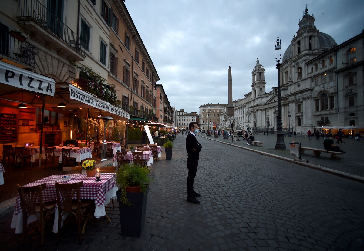 PEKERJA berada di depan restoran di dataran Piazza Navona di Rom pada 23 Oktober sebelum perintah berkurung pada waktu malam di wilayah Lazio, Itali.  FOTO AFP 