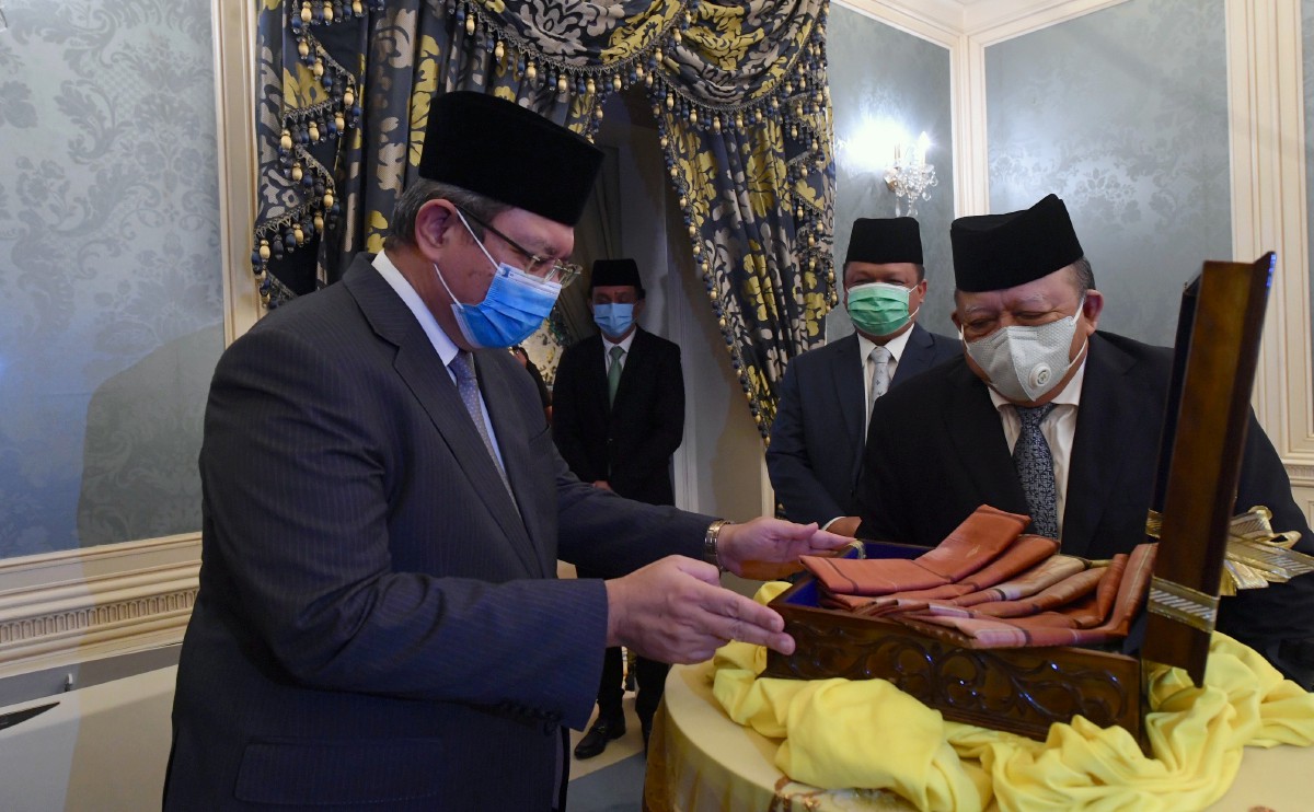 SAIFUDDIN (kiri) mempersembahkan Kain Tenun Pahang kepada Tuanku Syed Sirajuddin Putra Jamalullail. FOTO Bernama.
