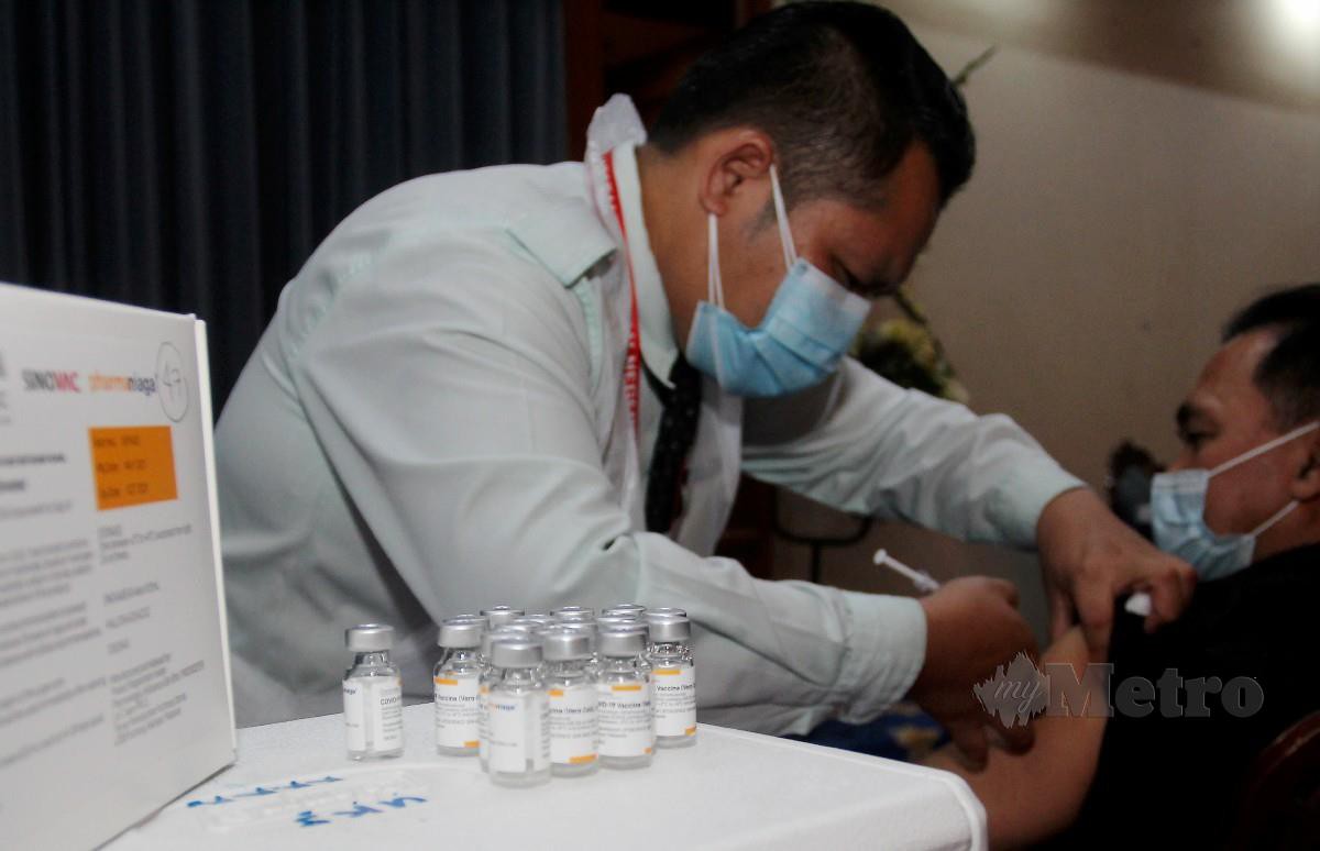 PETUGAS Petugas kesihatan memberi suntikan suntikan vaksin 19 jenis Sinovac kepada penerima. FOTO Nik Abdullah Nik Omar
