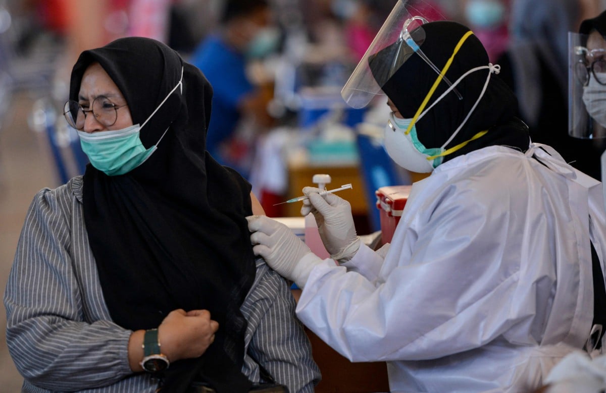 PETUGAS kesihatan menyuntik vaksin kepada penduduk di Banda Aceh. FOTO AFP.