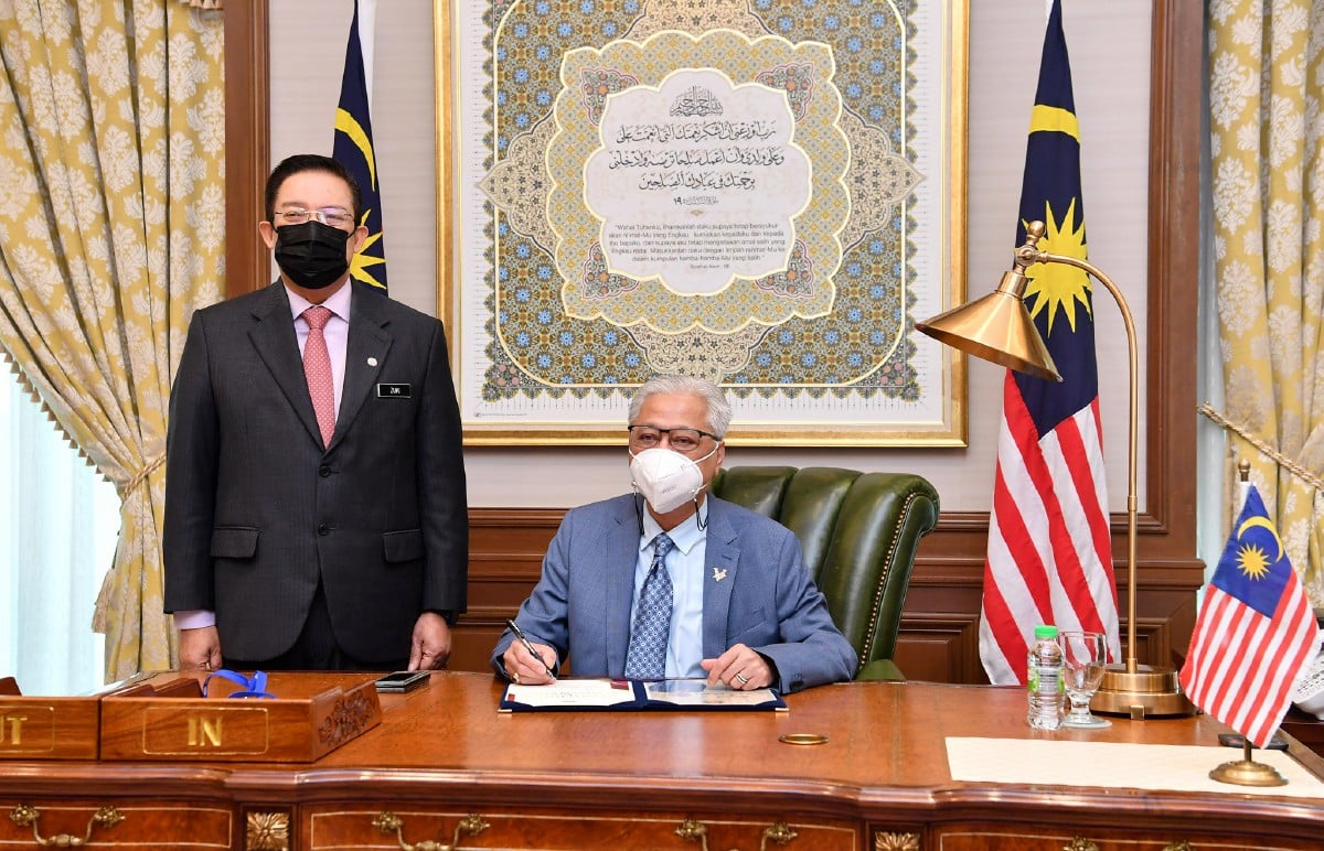 ISMAIL Sabri menandatangani buku selamat datang dan selamat bertugas di Perdana Putra hari ini. Turut sama Mohd Zuki (kiri). FOTO Bernama.