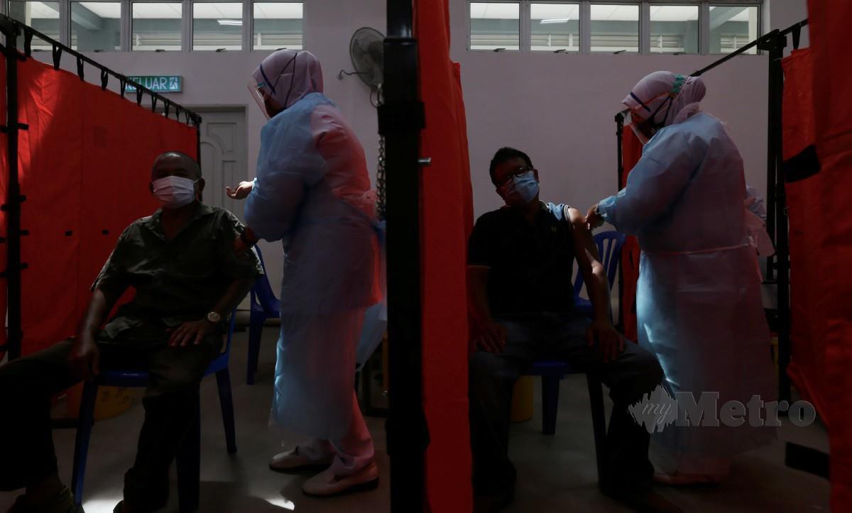 PENERIMA vaksin mendapatkan suntikan dos pertama vaksin di Pusat Pemberian Vaksin (PPV) Lanchang, Pahang. FOTO Farizul Hafiz Awang