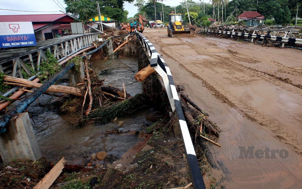 KERJA membuang lumpur serta baik pulih Jambatan Sungai Bujang, Jalan Pantai Barat , Tupah di sini, yang rosak akibat fenomena kepala air Gunung Jerai. FOTO Danial Saad
