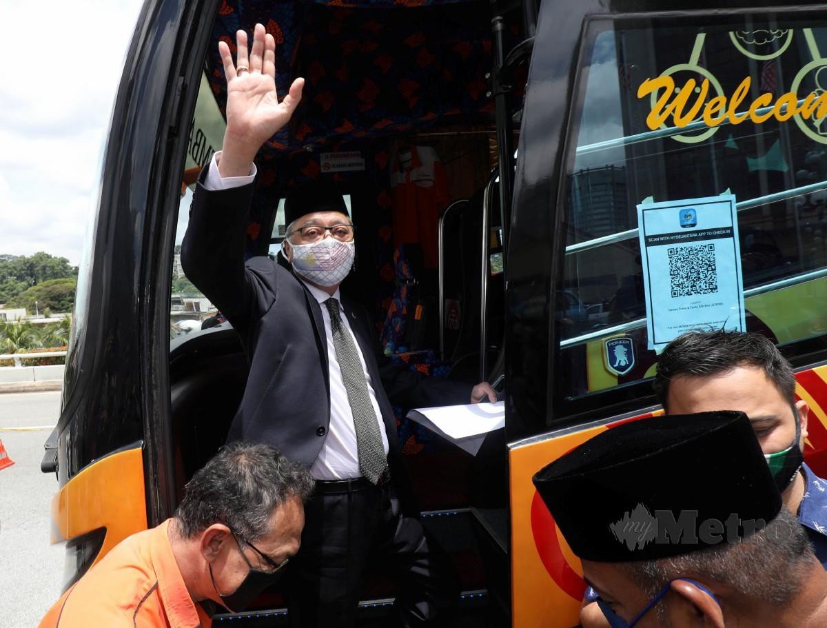 ISMAIL Sabri Yaakob bersama rombongan ahli Umno melambai tangan ketika  menaiki bas untuk mengadap Yang Dipertuan Agong di Istana Negara hari ini. FOTO Hazreen Mohamad.