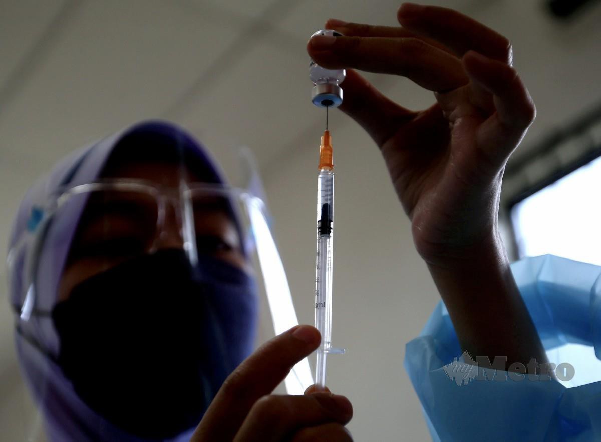 VAKSINATOR Unit Bergerak Vaksinasi Pejabat Kesihatan Daerah Seberang Perai Tengah (PKD SPT) mengisi picagari dengan vaksin Covid-19. FOTO Danial Saad