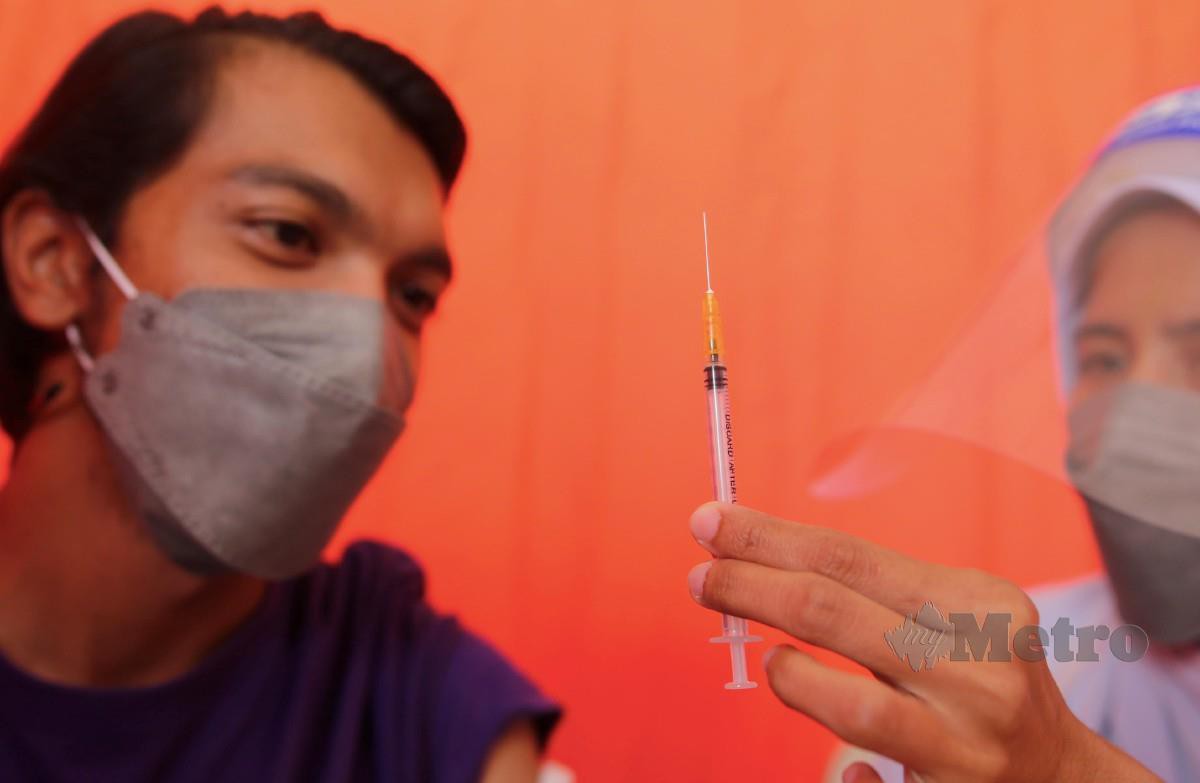PETUGAS kesihatan PKD daerah Kuantan, menunjukkan picagari yang sudah disuntik kepada penerima vaksin. FOTO Farizul Hafiz Awang