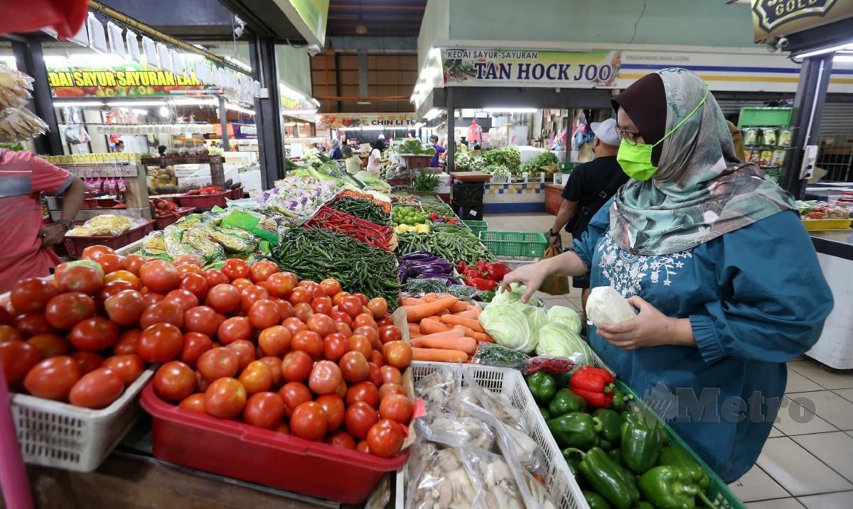 PENIAGA sayuran, Nor Fadzilah Hasbullah, 46,  menyusun stok sayur yang baru tiba di kedainya di pasar basah Tampoi, Johor. FOTO Nur Aisyah Mazalan