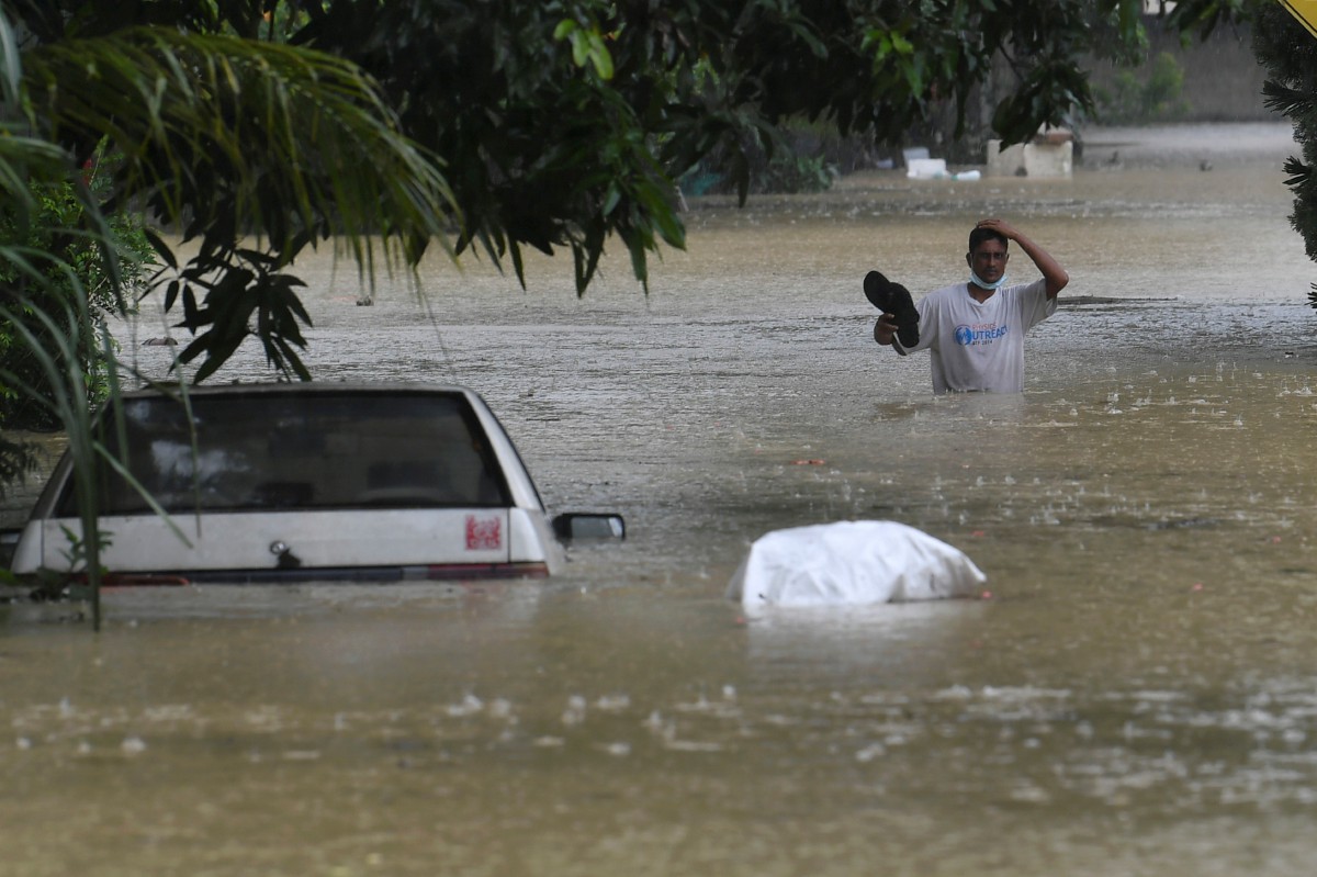 PENDUDUK meredah banjir susulan hujan berterusan di Kampung Dengkil hari ini. FOTO Bernama.
