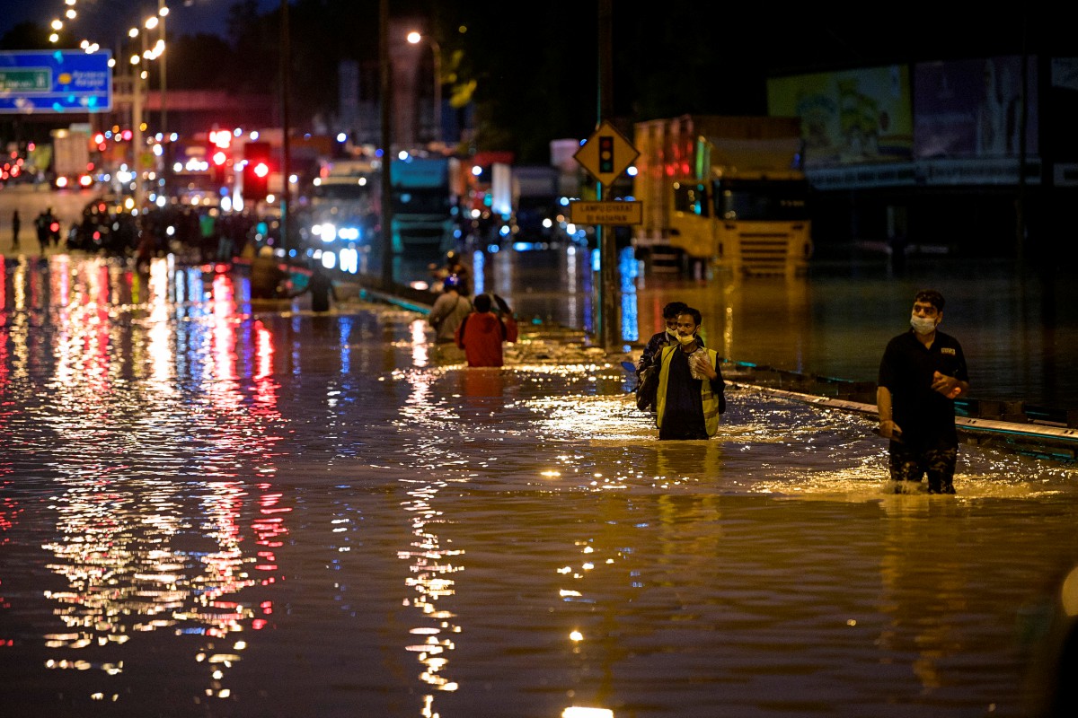 BEBERAPA orang awam meredah banjir akibat limpahan air dari Sungai Damansara dan mengakibatkan jalan di Batu 3 Lebuhraya Persekutuan ditenggelami air dan tidak boleh dilalui oleh kenderaan. FOTO Bernama.