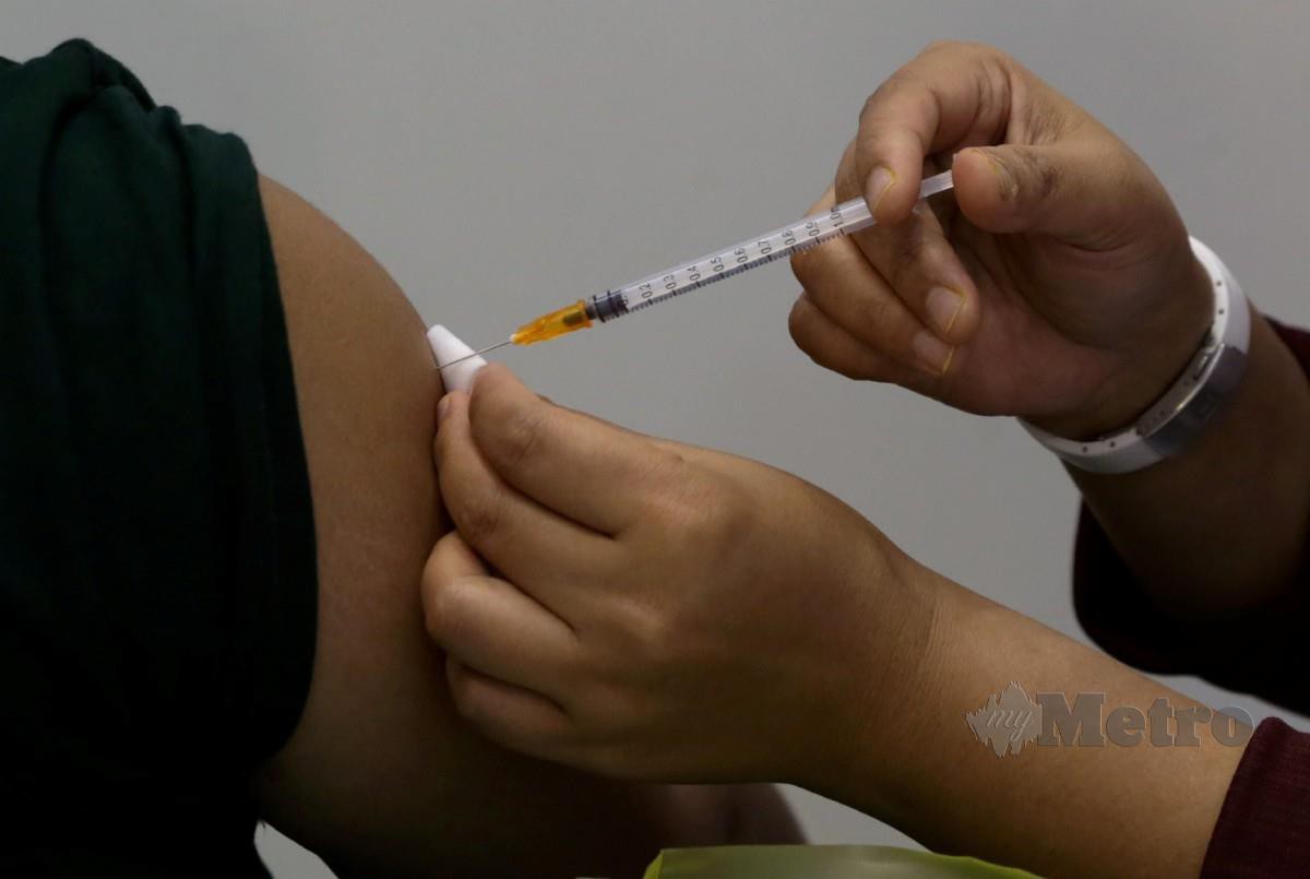 PEGAWAI perubatan memberikan suntikan vaksin Covid-19 kepada penerima di Pusat Pemberian Vaksin Offsite Tapak Ekspo Seberang Jaya. FOTO Danial Saad.