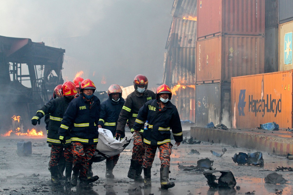 ANGGOTA bomba membawa mayat mangsa. FOTO AFP