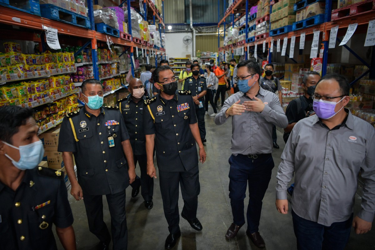 AZMAN (empat, kiri) diiringi Pengarah Sinsheng Tat Trading Sdn Bhd Teng Kah Hong (dua, kanan) memeriksa barangan keperluan harian. FOTO Bernama.