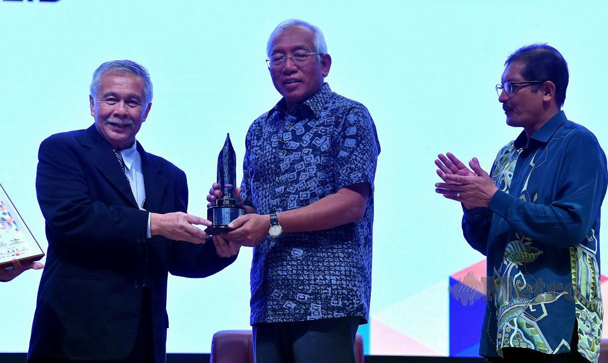 MAHDZIR (tengah) menerima Anugerah Perdana Tokoh Ilmuan Negara - UNESCO daripada Pengerusi Lembaga Pengelola Yayasan Pembangunan Buku Malaysia Tan Sri Prof Dr Abdul Latiff Abu Bakar. FOTO Bernama.