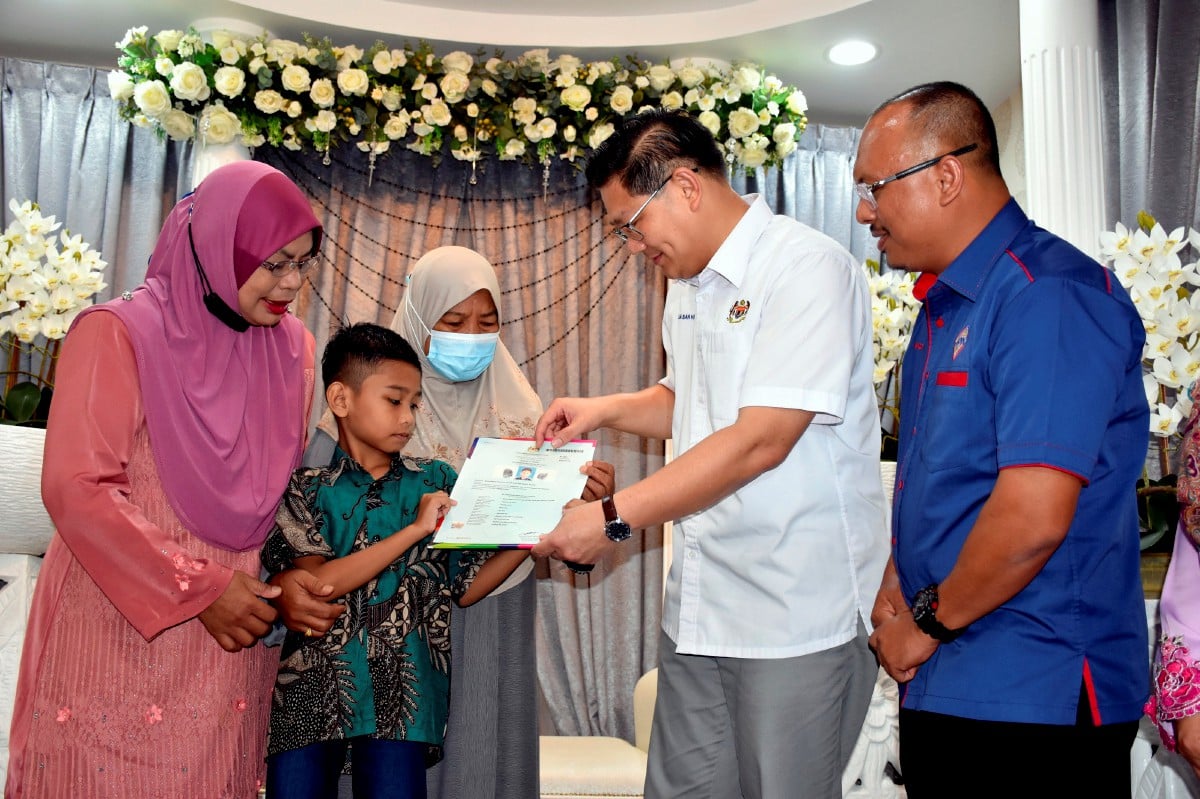 LIM (dua, kanan) menyampaikan sijil kewarganegaraan kepada Muhammad Shaffiq Izudin Aziz dan  Khadijah pada Program Temu Seru JPN Negeri Melaka  hari ini. Turut hadir Norazlee Sulaiman (kanan). FOTO Bernama.