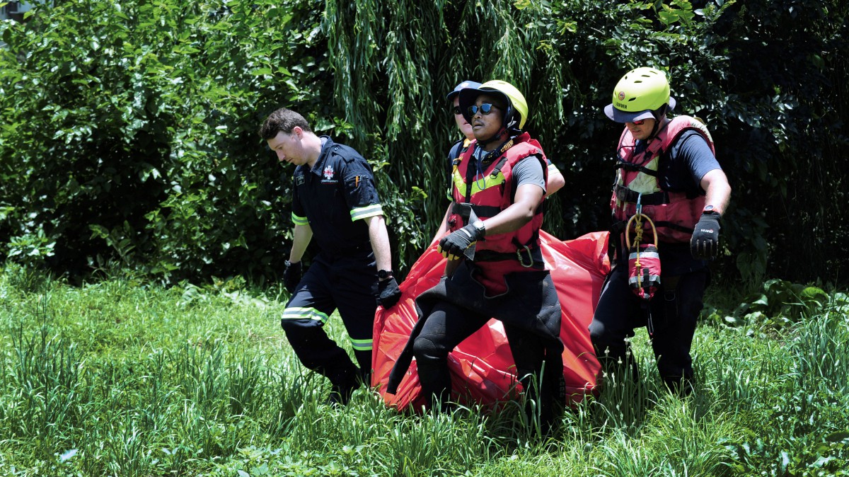 PASUKAN penyelamat membawa mayat mangsa banjir yang ditemui di Sungai Jukskei. FOTO AP