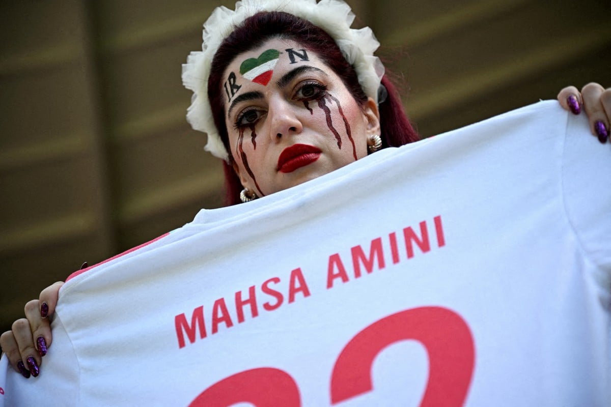 PEMINAT  bola sepak Iran memegang jersi bagi mengenang Mahsa Amini, di dalam stadium sebelum perlawanan Piala Dunia Qatar -Kumpulan B. FOTO Reuters