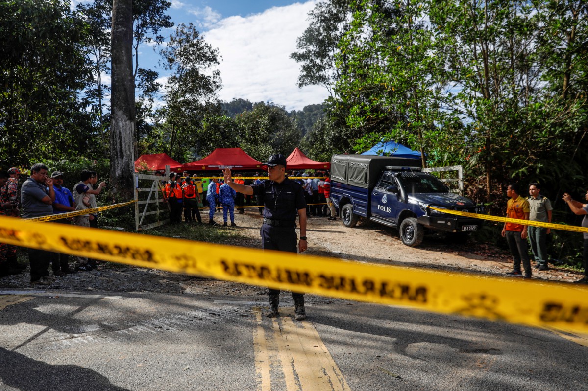 ANGGOTA polis mengawal di lokasi kejadian tanah runtuh di tapak perkhemahan di Batang Kali. FOTO EPA