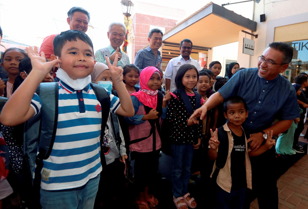 ADLY (kanan) beramah mesra bersama murid yang menerima bantuan Program Tanggungjawab Sosial Korporat (CSR) Back to School Tanjung Ratna Sdn Bhd. FOTO Bernama.