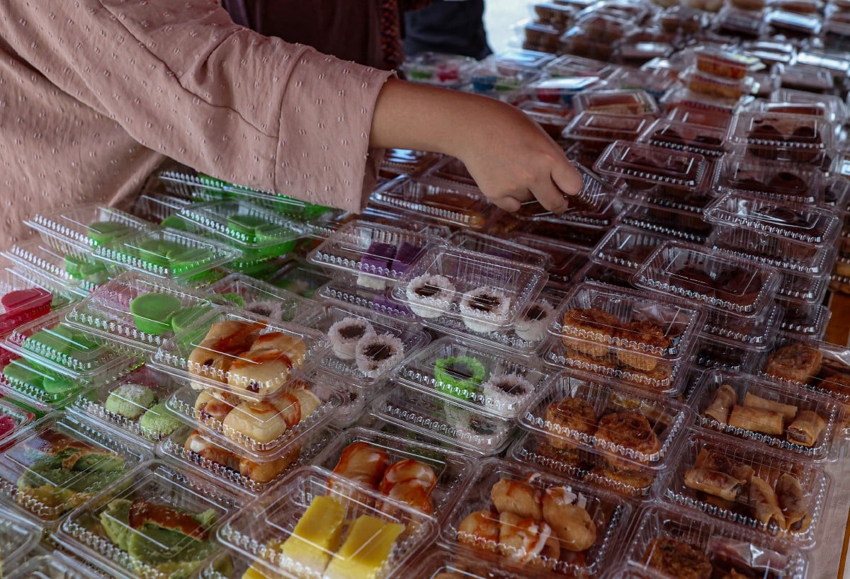 PELBAGAI juadah yang dijual pada harga RM1 sepaket di sebuah gerai di Taman Klebang Restu. FOTO Bernama.