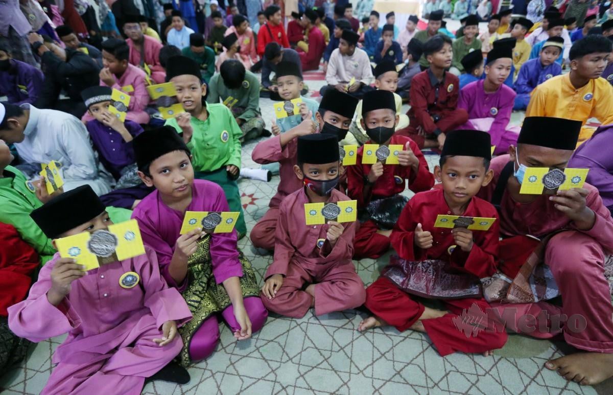 GELAGAT anak- anak yatim menerima duit raya pada majlis sumbangan Yayasan Islam Darul Ehsan (YIDE) di Masjid Kampung Raja Uda. FOTO Rohanis Shukri.