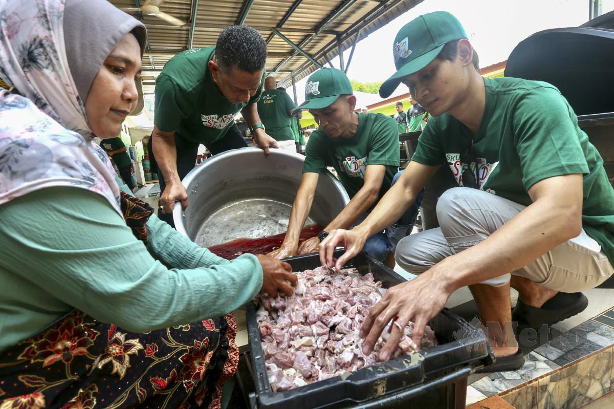 AMAN Aziz (kanan) bergotong-royong membasuh daging kerbau untuk dimasak gulai daging umbut pisang sempena program Seindah Kasih X Jom Ronda di Pondok Warga Emas Raudhatul Jannah Sik di sini. FOTO Danial Saad