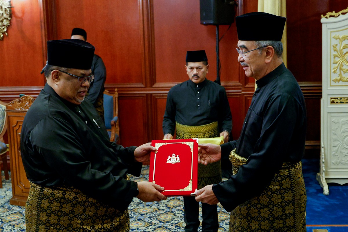 TUN Mohd Ali (kanan) menyampaikan Suratcara Pelantikan dan Angkat Sumpah Jawatan, Taat Setia serta Sumpah Simpan Rahsia Ketua Menteri Melaka Ke-13 kepada  Ab Rauf. FOTO Bernama