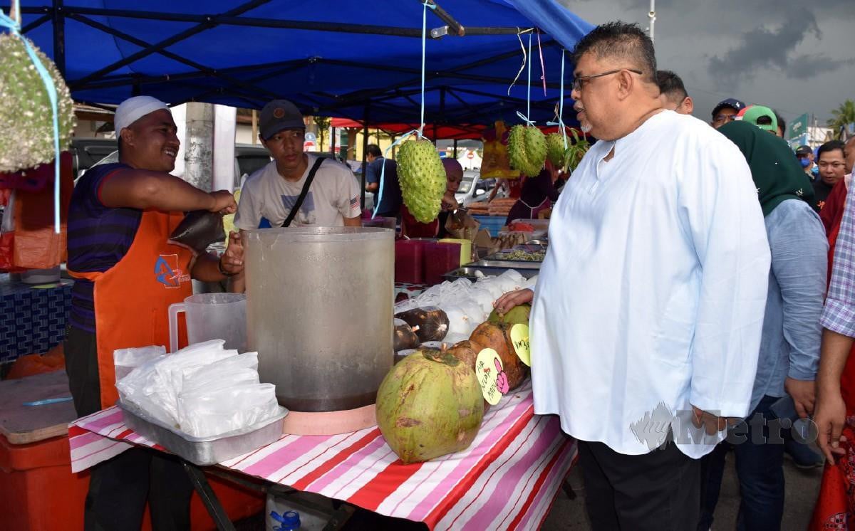 AB Rauf (kanan) melawat gerai jualan makanan dan minuman selepas melancarkan Bazar Ramadan Rahmah (BRR) Negeri Melaka di BRR Pekan Masjid Tanah hari ini. FOTO Rashidah Abd Rahim.