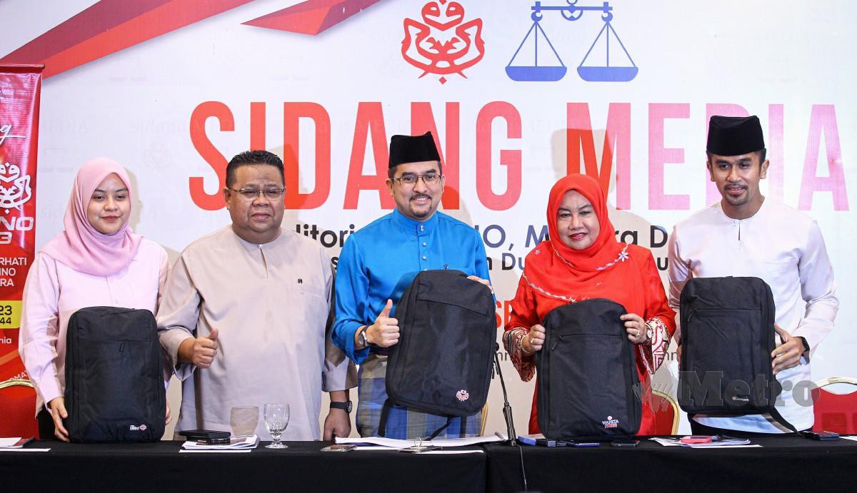 ASYRAF Wajdi (tengah) bersama-sama Setiausaha Wanita , Setiausaha Pergerakan Pemuda dan Puteri memegang beg yang akan diserahkan kepada perwakilan. FOTO  Aziah Azmee.