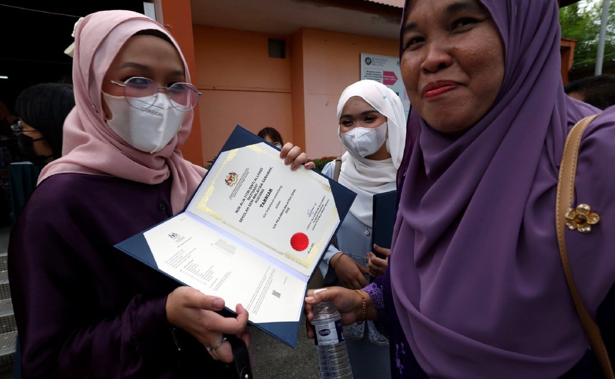 NUR Alia Fitri  menunjukkan keputusan  Sijil Pelajaran Malaysia (SPM) kepada ibunya Rosmawati Ahmad. FOTO Bernama
