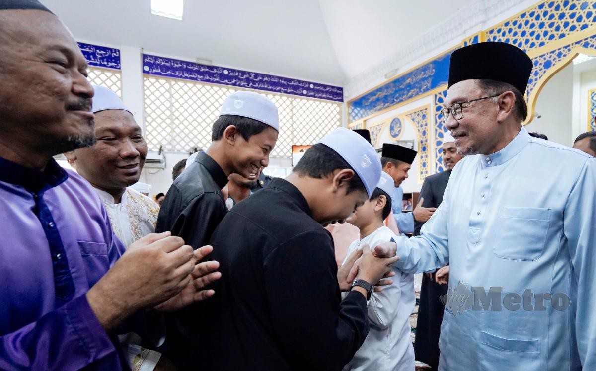 ANWAR bersalaman bersama orang ramai selepas menunaikan solat jumaat di Masjid Al-Ilmi, Dengkil. FOTO Mohd Fadli Hamzah