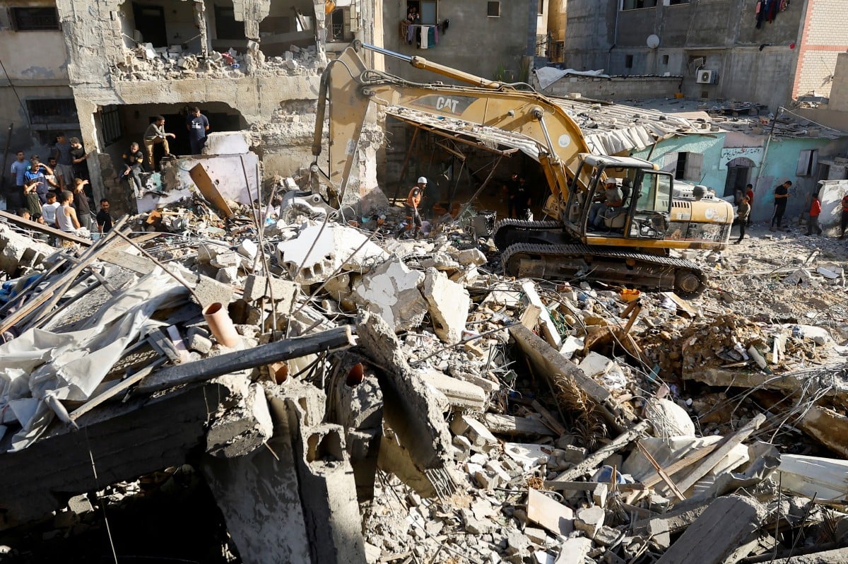 PENDUDUK Palestin berkumpul di kawasan bangunan runtuh akibat serangan Israel di Khan Younis. FOTO Reuters