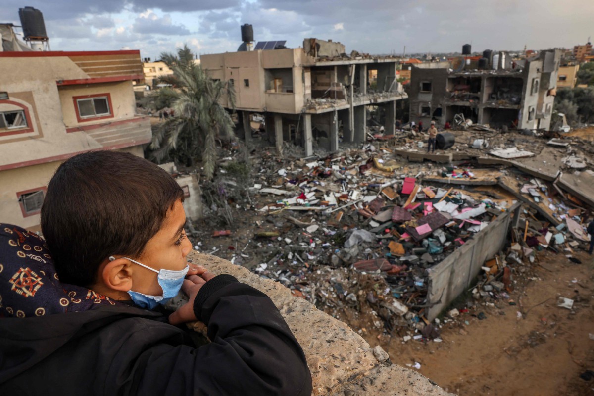 KANAK-kanak Palestin melihay kemusnahan bangunan susulan serangan Israel di Rafah. FOTO AFP